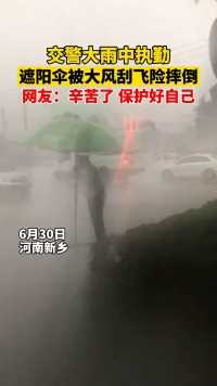河南新乡，交警在风雨中坚守遮阳伞被大风刮飞，网友：辛苦了，保护好自己！