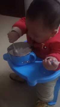 11个月的小宝宝自己会动手吃饭了。