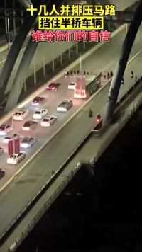 4月16日，广西南宁八尺江大桥，一群人并排压马路，致使桥上车辆无法正常通行。网友：都什么年代了，还装古惑仔